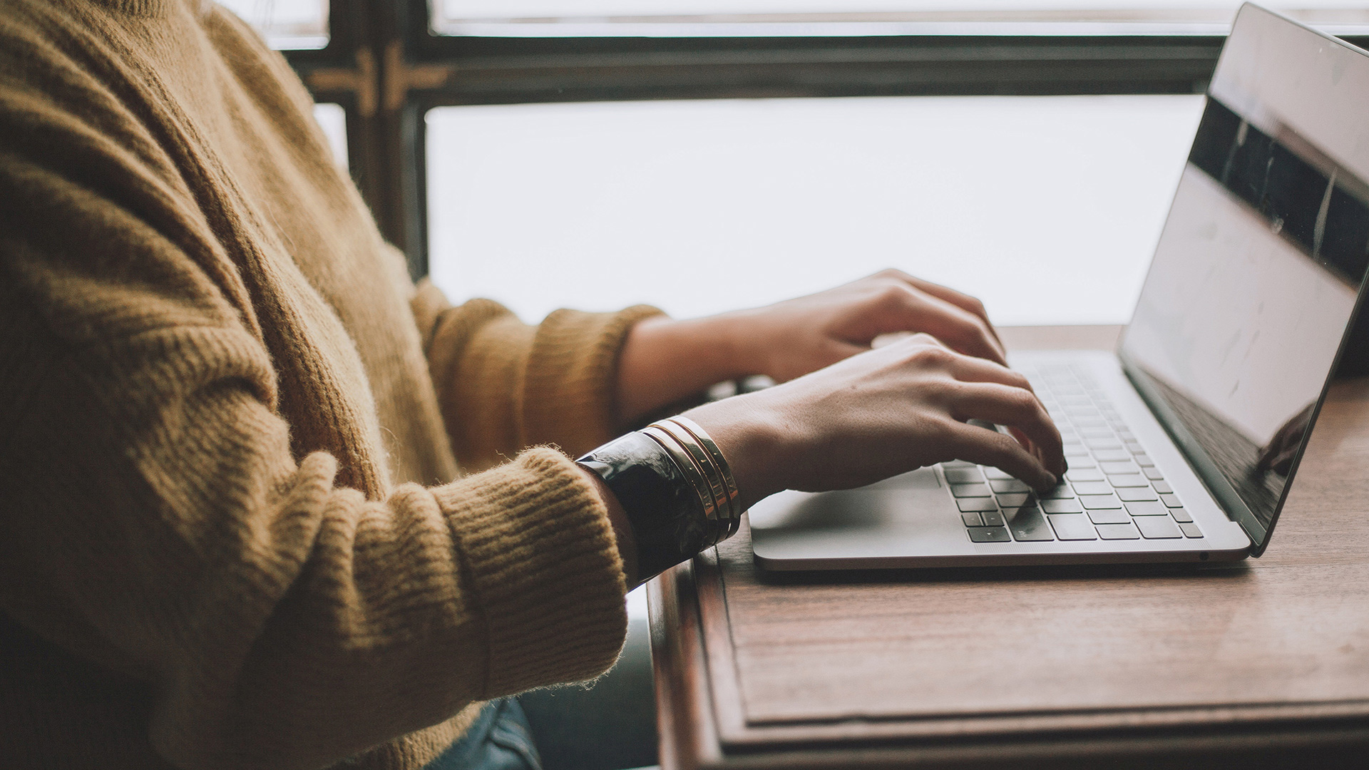 Woman researching best super consolidation methods on laptop