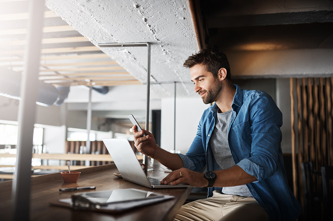 Man using computer and mobile
